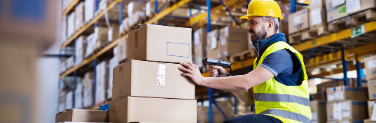 Man in a warehouse scanning boxes