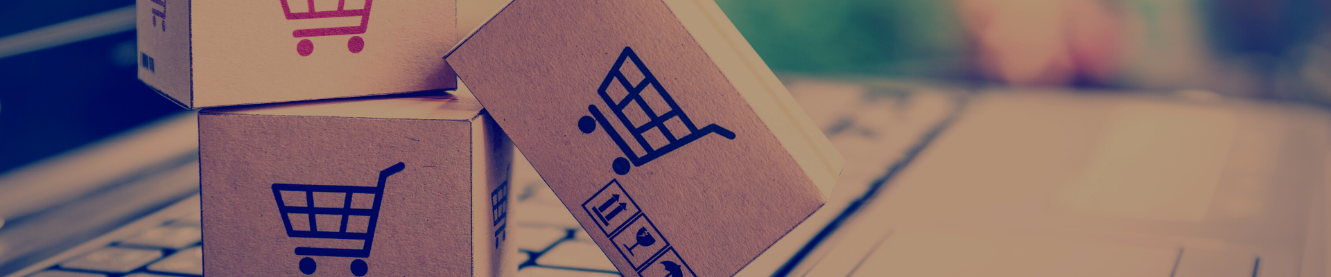 Little packages in a trolley on a laptop to indicate ecommerce